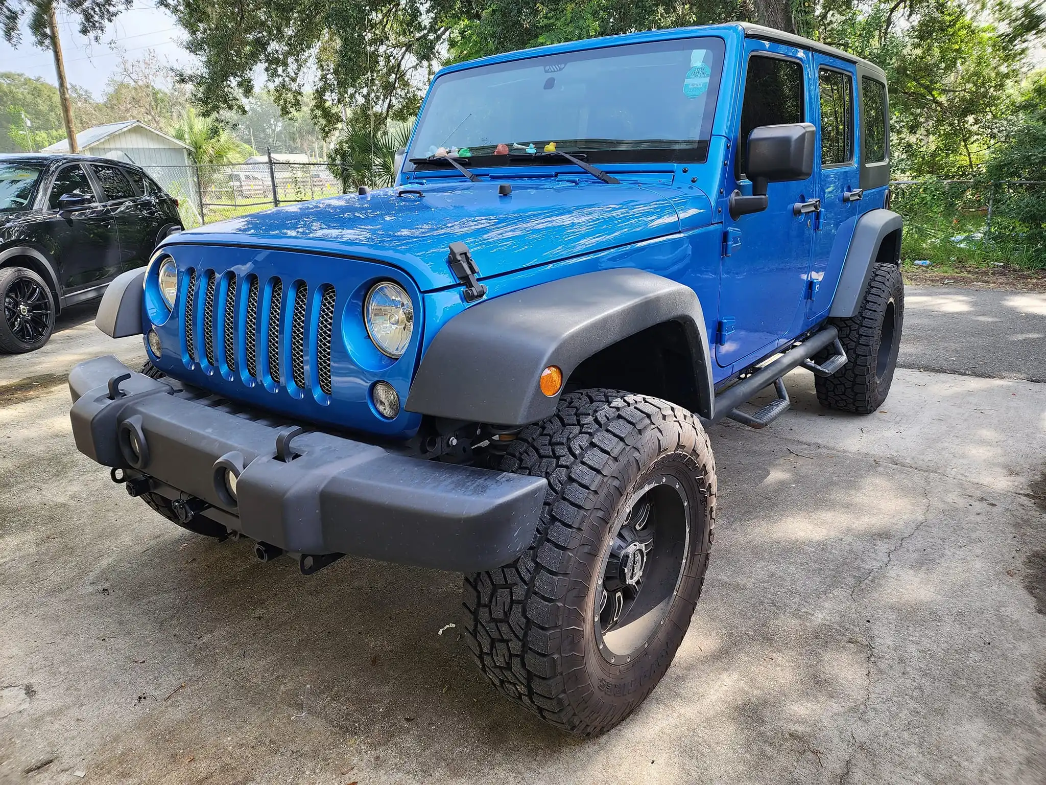Blue Jeep Wrangler Rubicon exterior detailing with off-road tire cleaning and paint protection