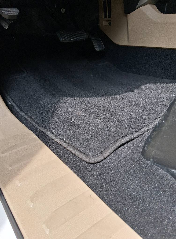 Restored black car carpet after deep cleaning and professional detailing service