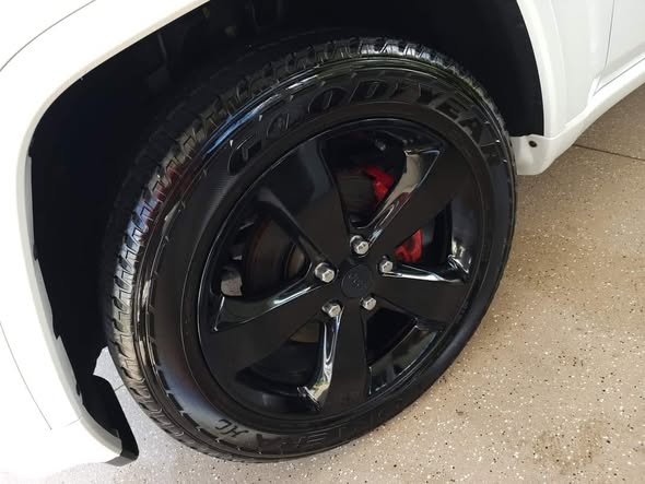 Clean vehicle wheel and tire after professional detailing service showing restored finish