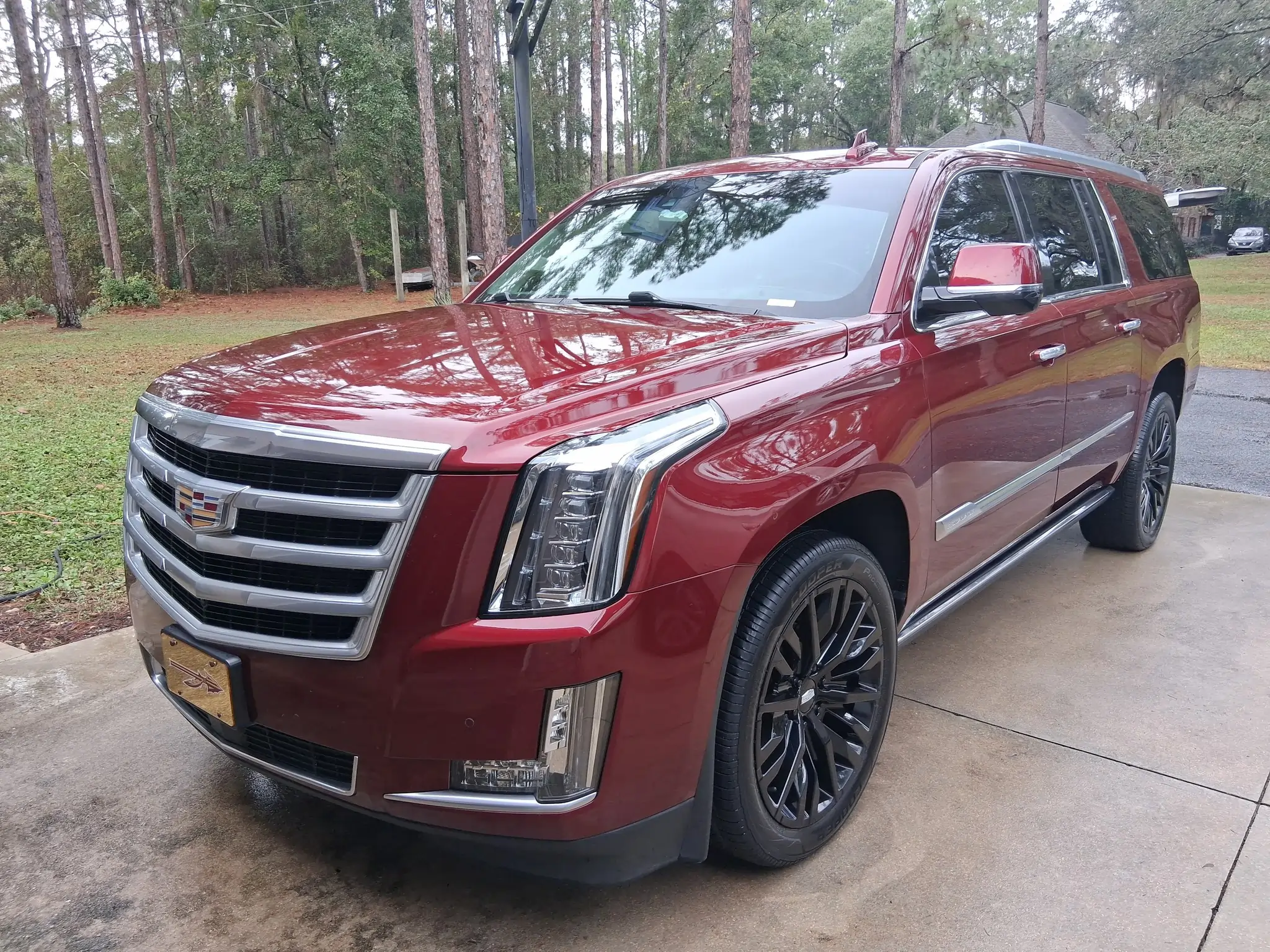 Deep red Cadillac Escalade exterior detailing with gloss enhancement and blacked-out alloy wheels
