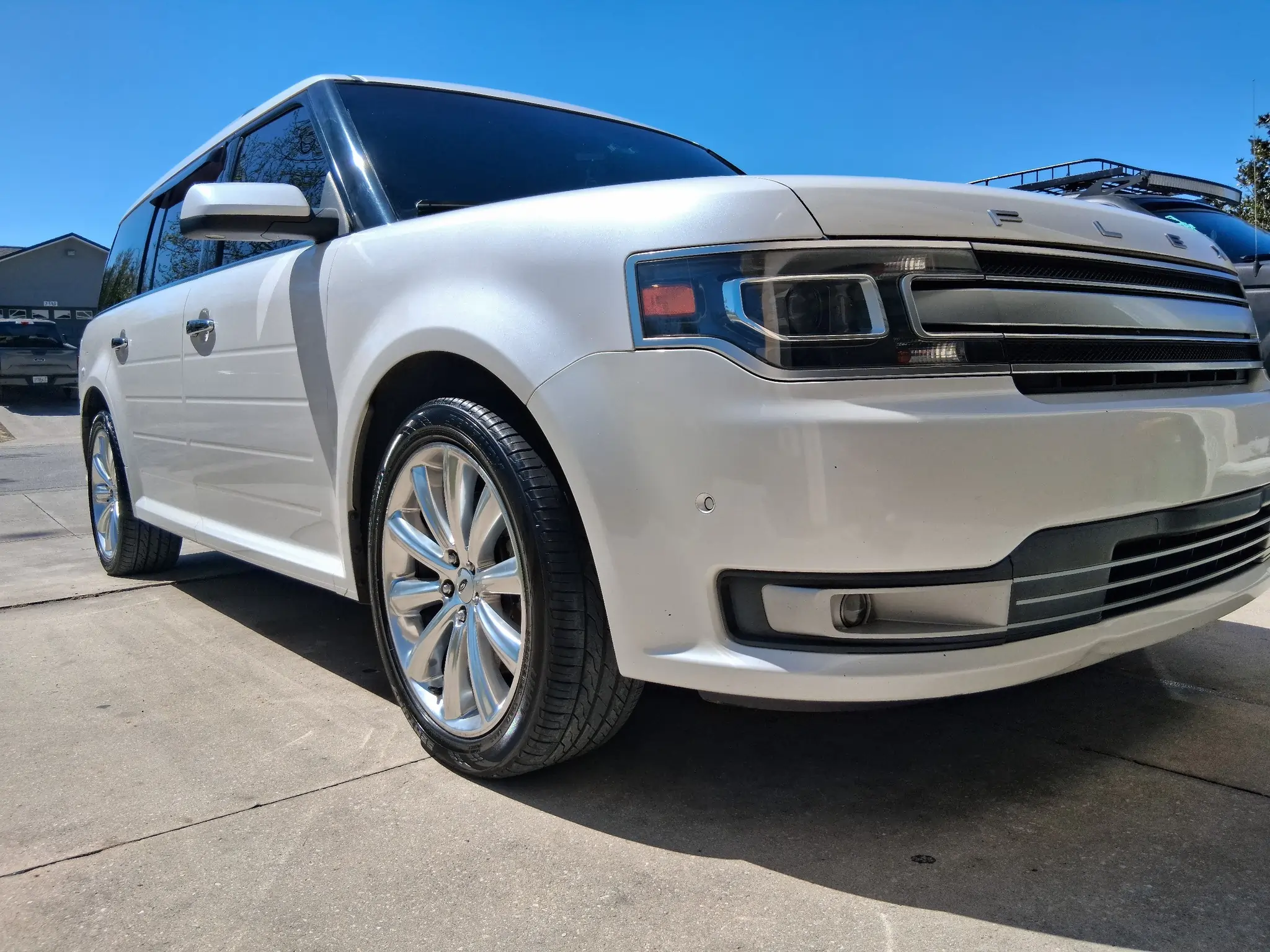 White Ford Flex exterior detailing with high-gloss tire shine and polished chrome wheels