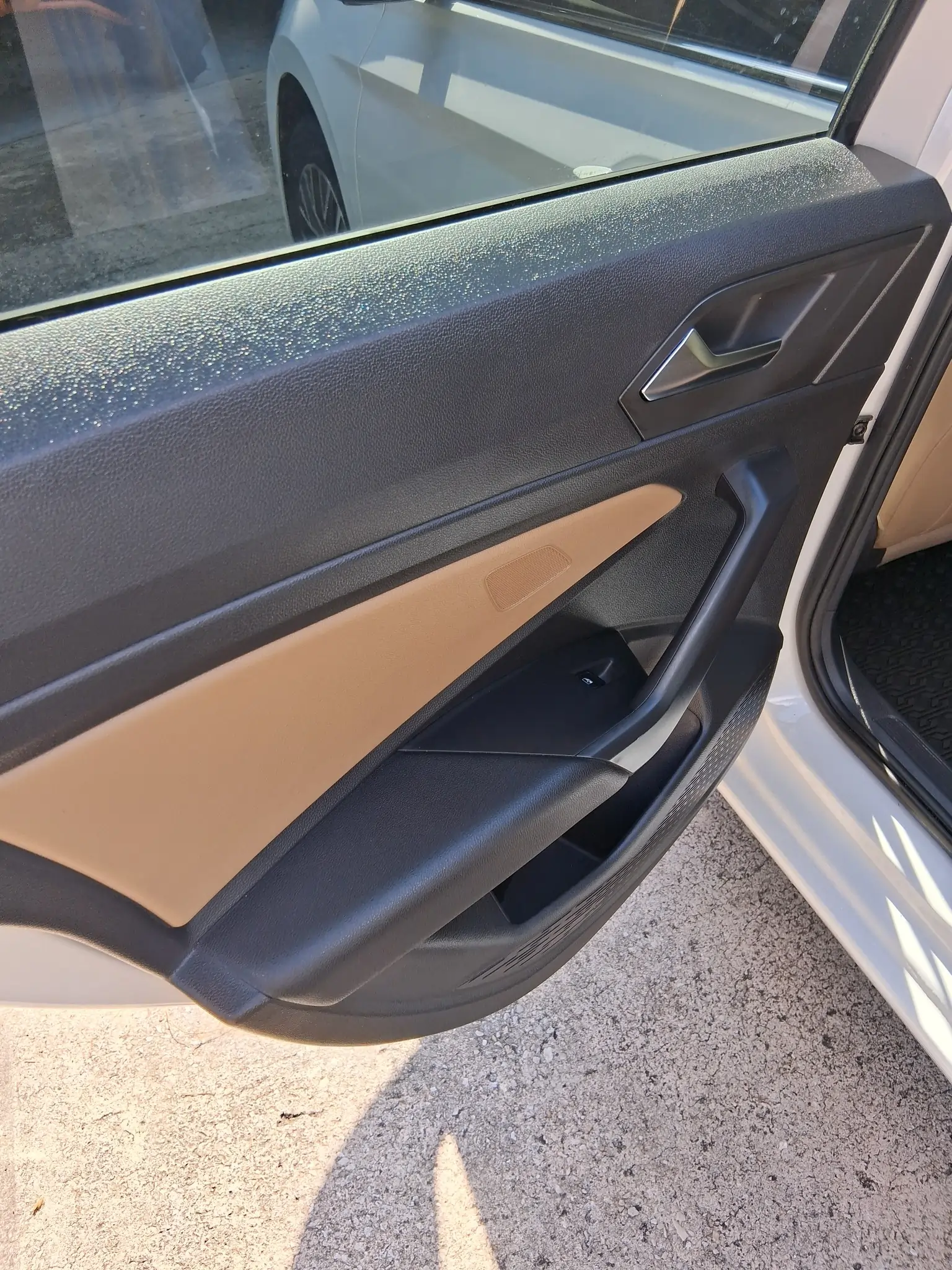Close-up of interior door panel detailing on a modern vehicle with two-tone leather accents