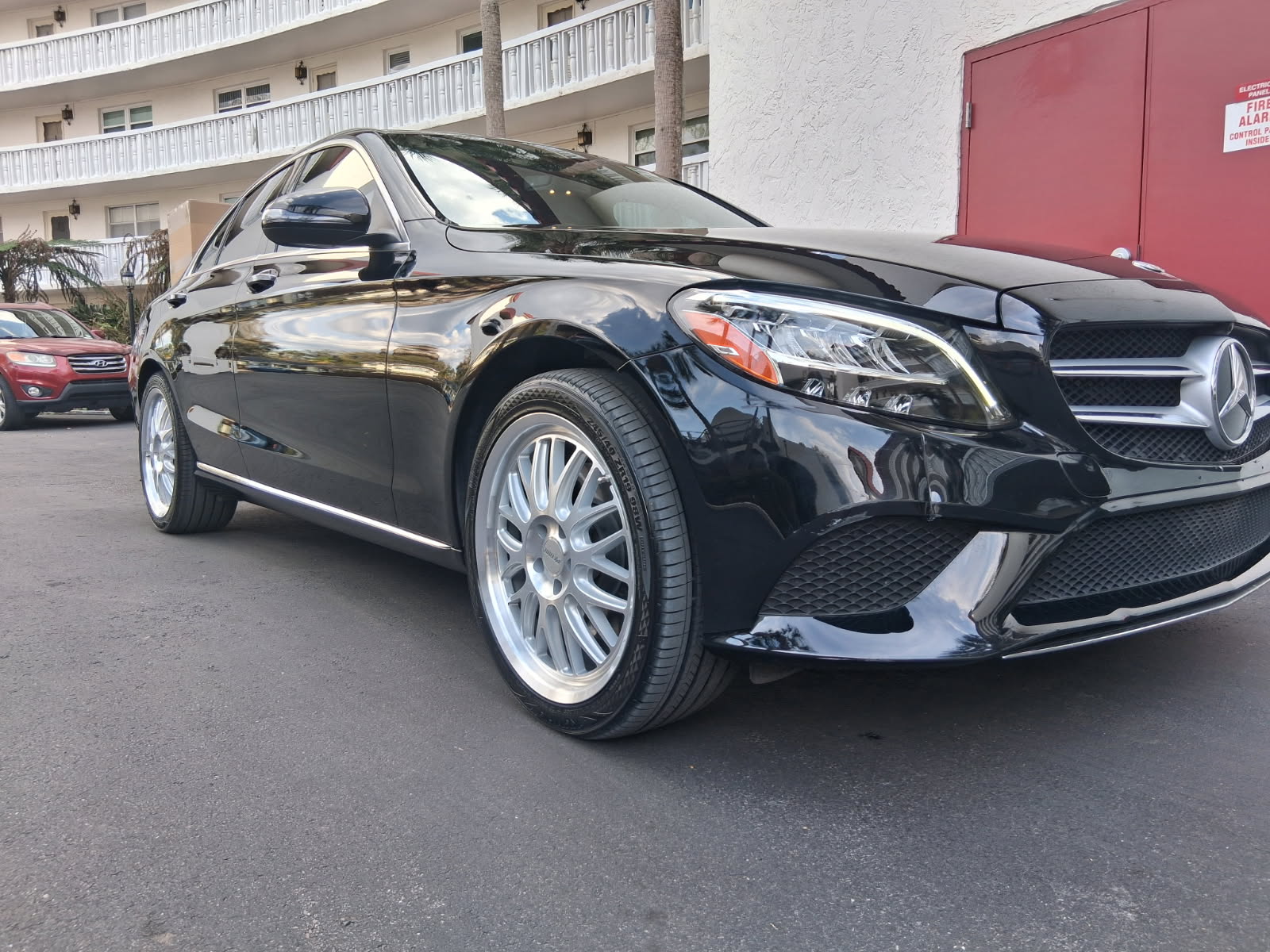 Showroom-quality paint correction and ceramic coating on a black Mercedes-Benz C-Class sedan with polished alloy wheels