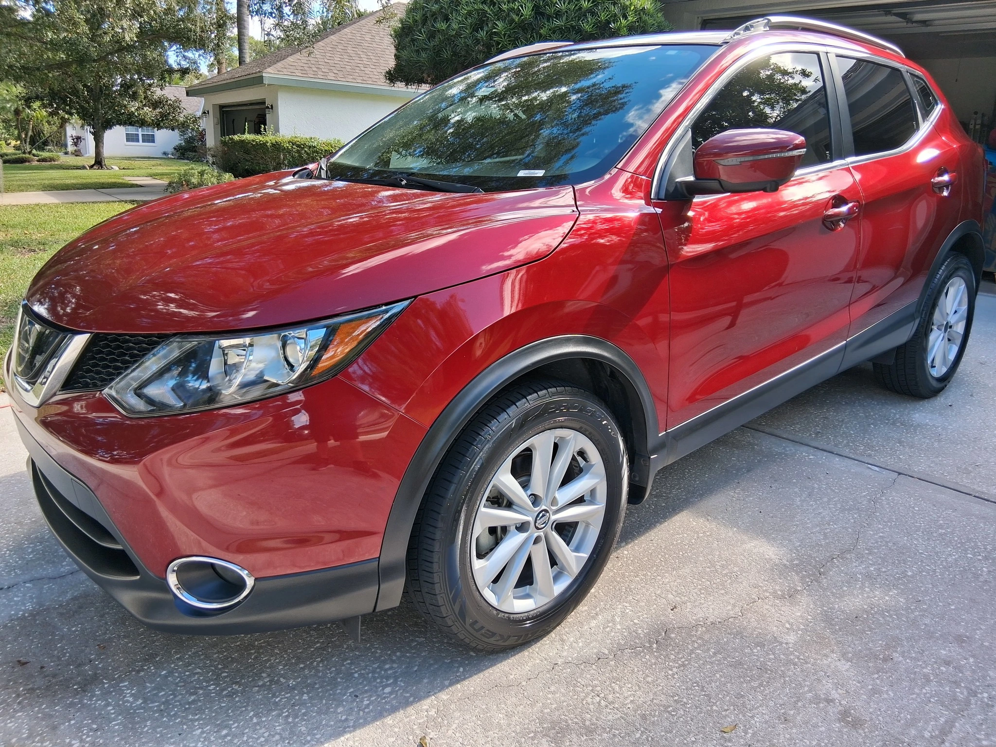 Red Nissan Rogue Sport exterior detailing showcasing premium auto spa wash and wax services